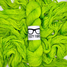 Load image into Gallery viewer, Bright green yarn with a 'Feisty Fibres' label on a white background