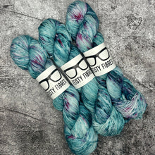 Load image into Gallery viewer, A skein of pink merino linen yarn with a label that reads &#39;Feisty Fibres&#39;, surrounded by unspooled yarn.

