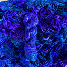 Load image into Gallery viewer, Purple and Blue yarn skein on a background of blue and purple yarn
